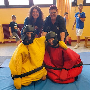 Kinder und Jugendliche nehmen bei der inklusiven Ferienfreizeit in Rastatt unter Anleitung des JJKSV am Sumo-Ringen teil.